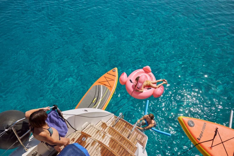 view from a catamaran into the sea with surf-boards