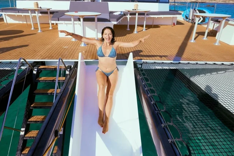 woman on a slide on board of a catamaran